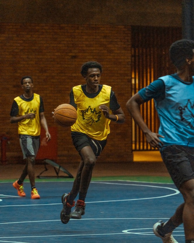 Adult dribbling a basketball in an organized game in The REC Competitive Division